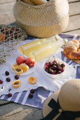 Beautiful cozy summer picnic on a lake with fresh fruits, cheese and lemonade.