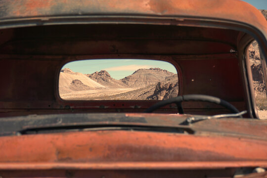 View Through Back Window Of Old Rusty Truck Of Desert Mountain Landscape