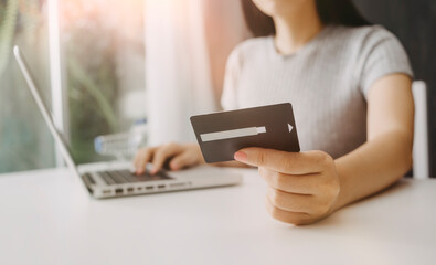 businesswoman hand using smart phone, tablet payments and holding credit card online shopping, omni channel, digital tablet docking keyboard computer at office in sun light