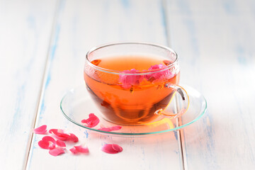 Tea in a glass cup on the white table.
