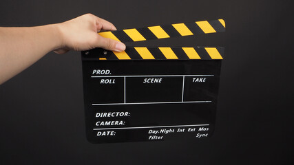 Hand is holding yellow and black color movie slate.It is used in video production and film industry...