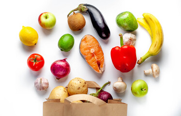Paper bag with various products from store on white background. Healthy food.
