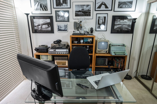 Home office with vintage electronic collectables on shelves and framed black and white photos on wall.  Wall art is the phtotgraphers work.  