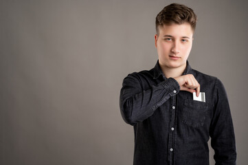 Portrait of serious stylish attractive man dressed with a casual black shirt take card out of pocket