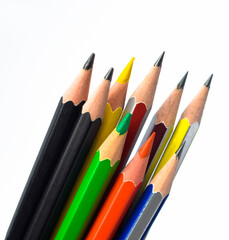 Some different colored wood pencil crayons stocked together on a white background