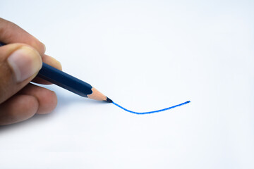 A person marking blue line on a white paper background with his fingers