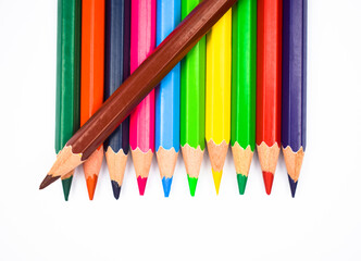 Brown color wood pencil crayon placed on top of a row of different color wood pencil