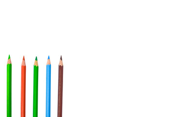 Four different color wood pencil crayons placed at a one side of a white paper