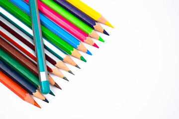 Light blue color wood pencil crayon placed on top of a row of different color wood pencil