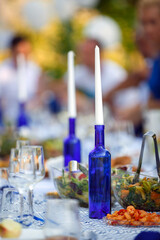 A candle in a blue bottle on the Banquet table