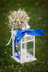 Interior lamp with a candle, a blue bow, a bouquet of flowers