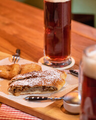 Dark, black beer mugs with sweet dessert