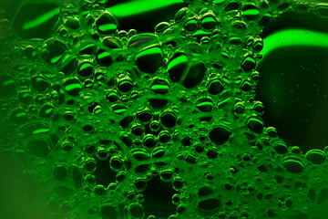 Soap bubbles on a rich green neon background.The shape and texture of the foam.gradient green color.macro mode.