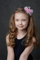 Portrait of a young long haired girl wearing rose hairband and looking at camera