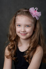 Portrait of a young long haired girl wearing rose hairband and looking at camera