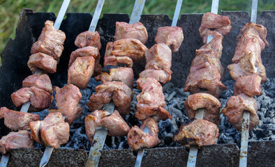 Cooking marinated shashlik on the grill. Large fried pieces of meat on skewers.