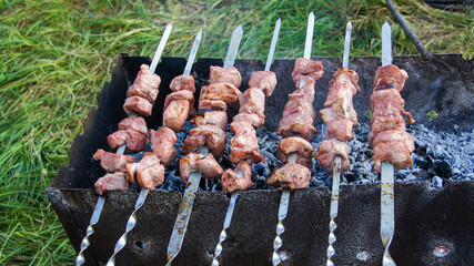 Cooking shish kebab on coals in an old grill.