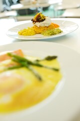 Fine dining food and drink being prepared and displayed in classic white crockery in a kitchen environment,