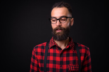 Obraz premium Young handsome Persian man with dreadlocks against black background