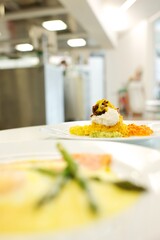 Fine dining food and drink being prepared and displayed in classic white crockery in a kitchen environment,