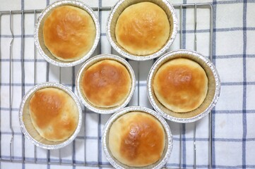 In selective focus many homemade butter bread in a foil cup  on white table cloth top view