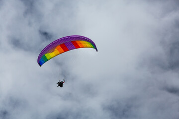 Farbiger Gleitschirm vor grauen Wolken