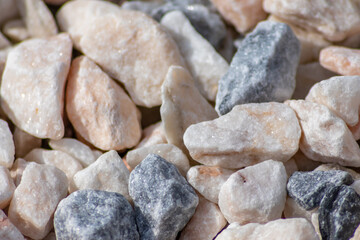 Raw rocks and minerals as natural stones background with crushed and rough material at a rough coast or rocky beach show nuggets and sandstones in harmonic pastel colors