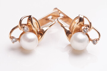 Pair of earrings with pearls shot on light surface