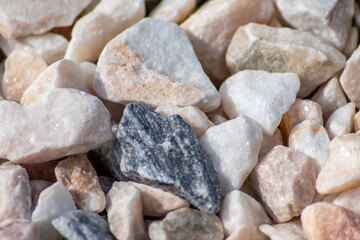 Raw rocks and minerals as natural stones background with crushed and rough material at a rough coast or rocky beach show nuggets and sandstones in harmonic pastel colors