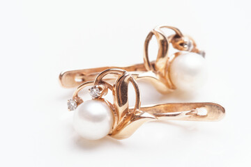 Pair of earrings with pearls on light surface
