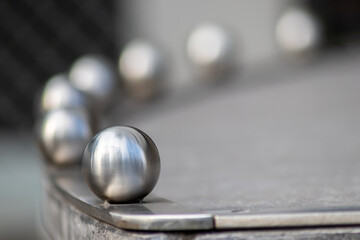 Matt steel balls in a row as decorative and ornamental balustrade and futuristic fence design with a lot of copy space, a selective focus and a blurred background for metal industry metal architecture