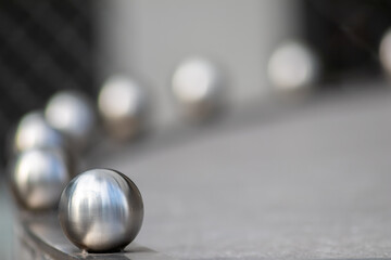 Matt steel balls in a row as decorative and ornamental balustrade and futuristic fence design with a lot of copy space, a selective focus and a blurred background for metal industry metal architecture