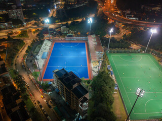 Aerial bird’s eye view of the outdoor hockey field at night. The image contains soft-focus,...