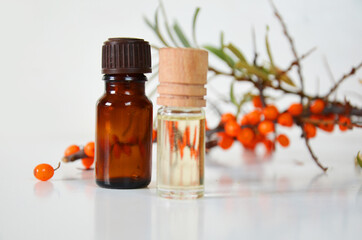 sea-buckthorn berries cluster and oil bottle jar isolated on a white background