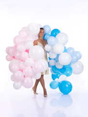 A girl in a white dress with balloons poses on a white background.