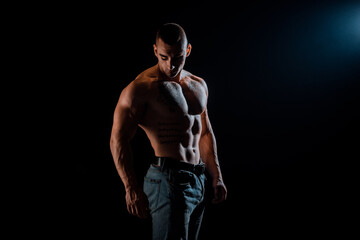 Fototapeta na wymiar Strong athletic muscular man on dark background