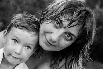 Young woman with a young son, a black-and-white portrait after a swim.