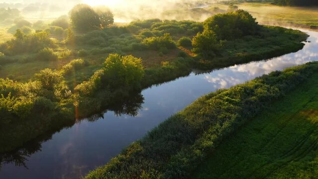 Morning summer landscape.Beautiful nature at sunrise top view. Fog over a meadow with a river.