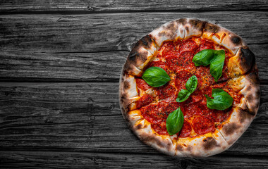 Pepperoni Pizza with Mozzarella cheese, salami, Tomato sauce, pepper, Spices and Fresh basil. Italian pizza on wooden table background