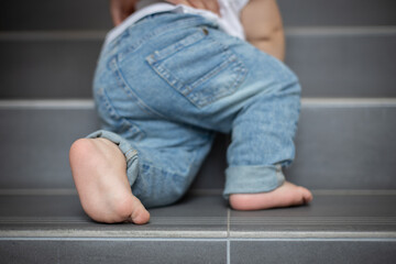 baby climbs the stairs, little feet on the steps, the first steps, dangers for a small child,...