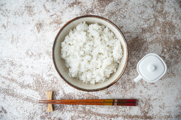 japanese white rice in a bowl with soy sauce bottle