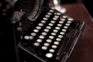 Retro typewriter with round keys placed on wooden table in old fashioned office