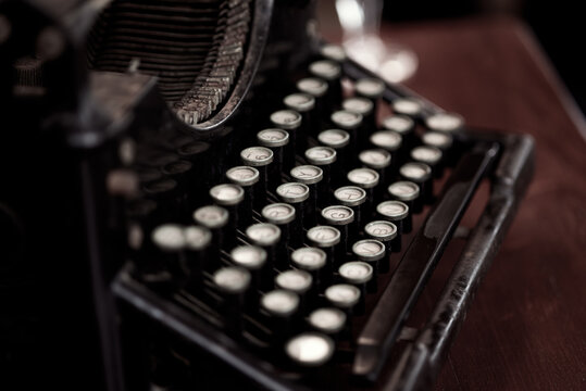 Retro typewriter with round keys placed on wooden table in old fashioned office