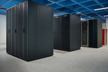 Interior of modern illuminated facility with metal server racks placed in rows