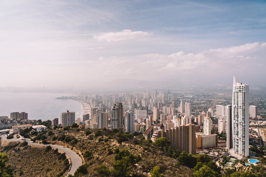 From above cityscape of densely built Benidorm city district with contemporary skyscrapers covered with haze in Spain