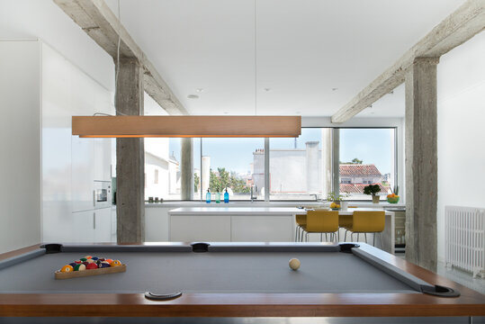 Billiard table with balls located in modern flat in minimalist style with white walls