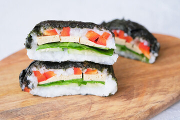 Onigirazu, vegan sushi sandwich with vegetables (cucumber, pepper, spinach) and tofu. Trend Japanese food. Healthy food concept..