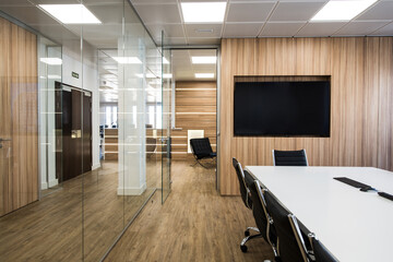 Interior of modern office with table and chairs located in room with glass walls