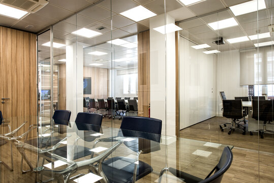 Interior of modern office with table and chairs located in room with glass walls