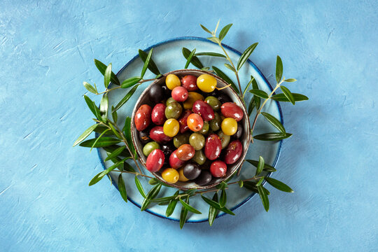 Olives. A variety of green, black and red olives, with leaves, overhead shot
